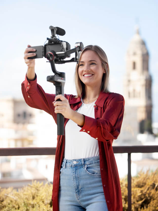 A lady adjusting her phone on a selfie pod